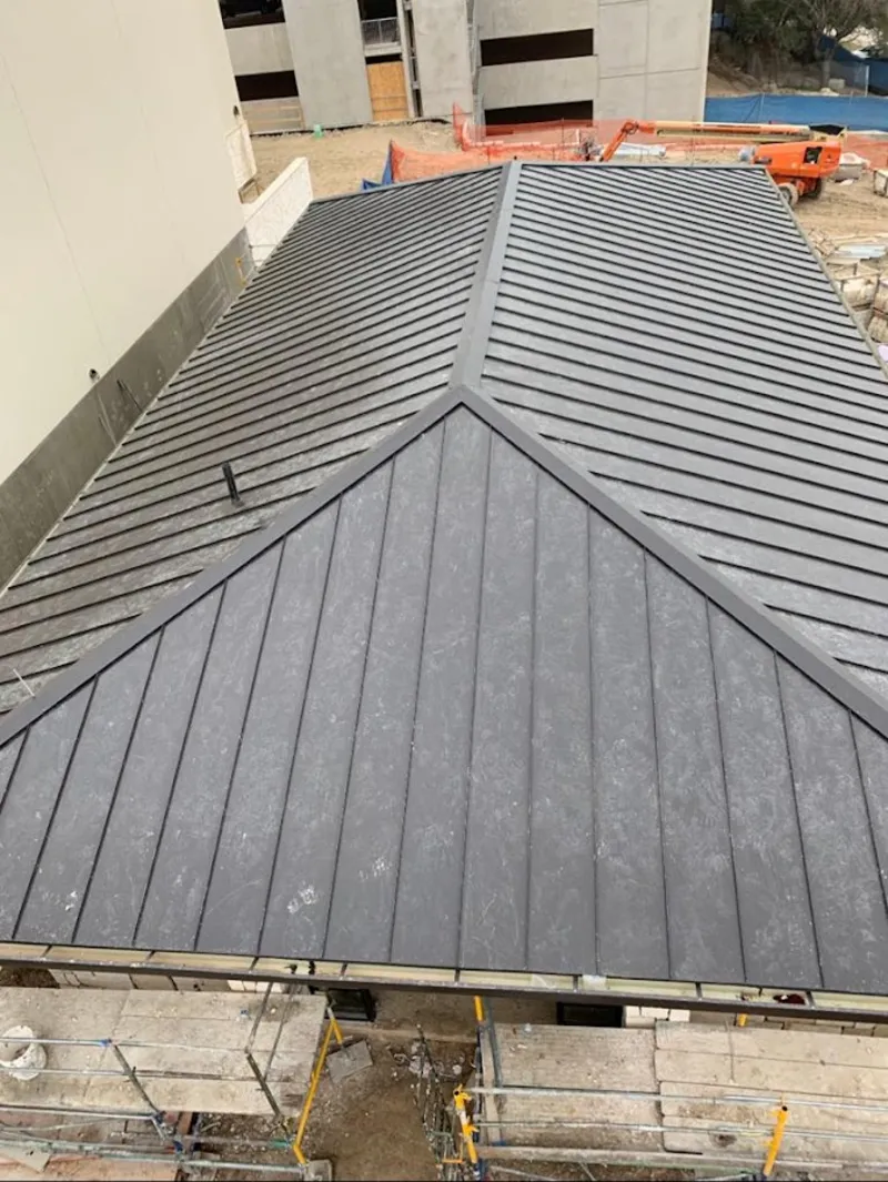 Commercial metal roof construction with crane equipment in Luling