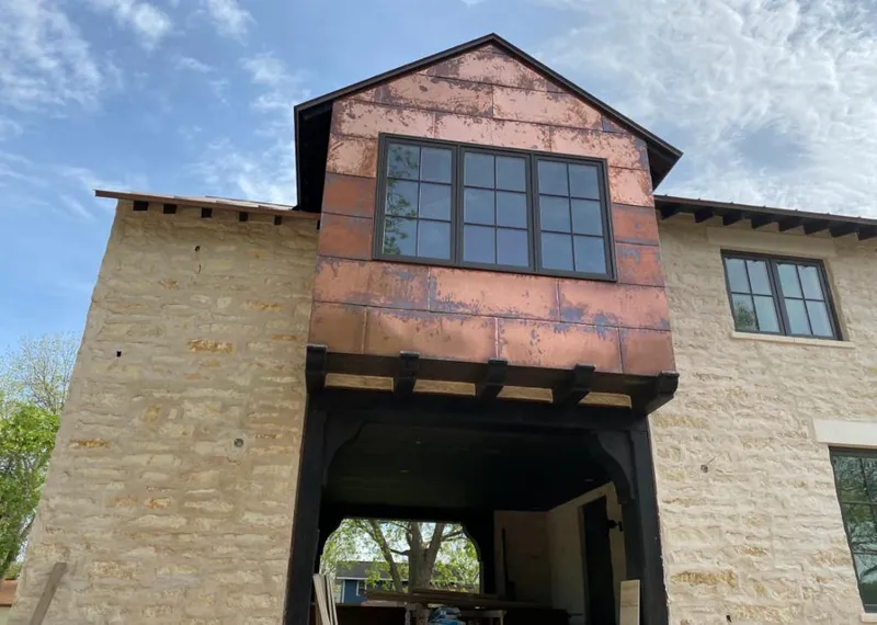 Copper metal panel facade on a stone building for Skylight Installation in Luling